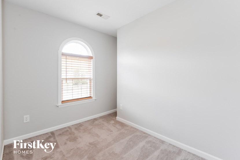 an empty room with a window and white walls