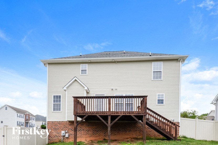a large white house with a deck and a blue sky