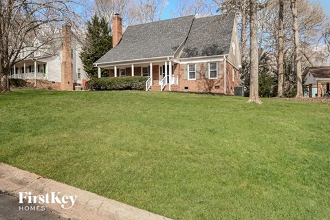a large lawn in front of a brick house
