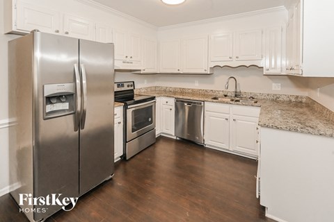 a kitchen with stainless steel appliances and white cabinets