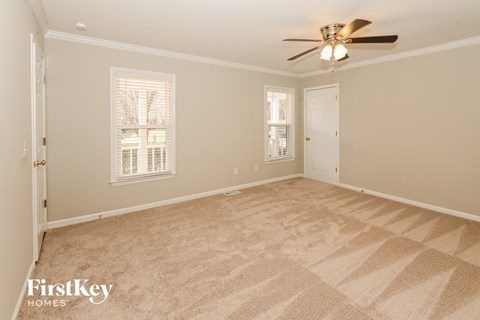 a living room with carpet and a ceiling fan