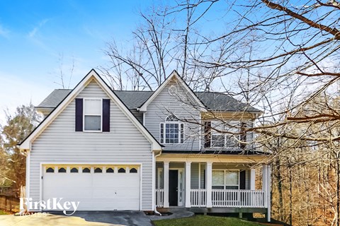 a white house with a porch and a white garage door