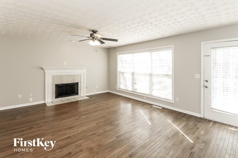 a living room with a fireplace and a ceiling fan
