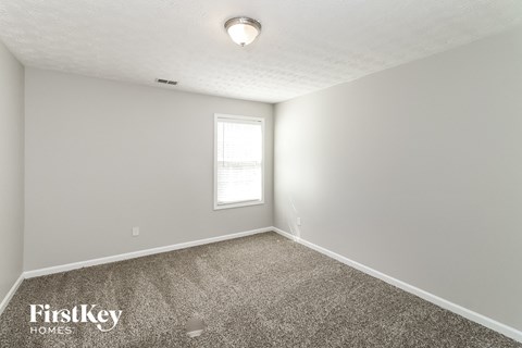 a bedroom with a carpeted floor and a window