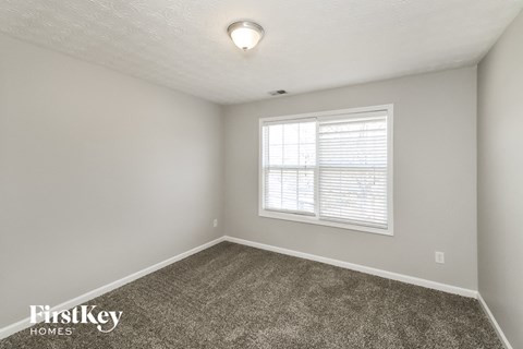 a bedroom with a carpeted floor and a window