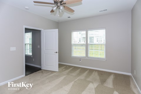 a living room with a ceiling fan and two windows