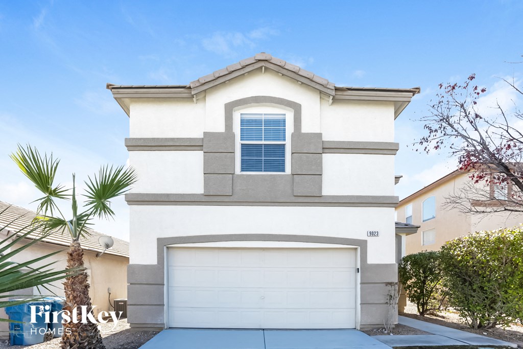 A two-story house with a garage and a window on the second floor.