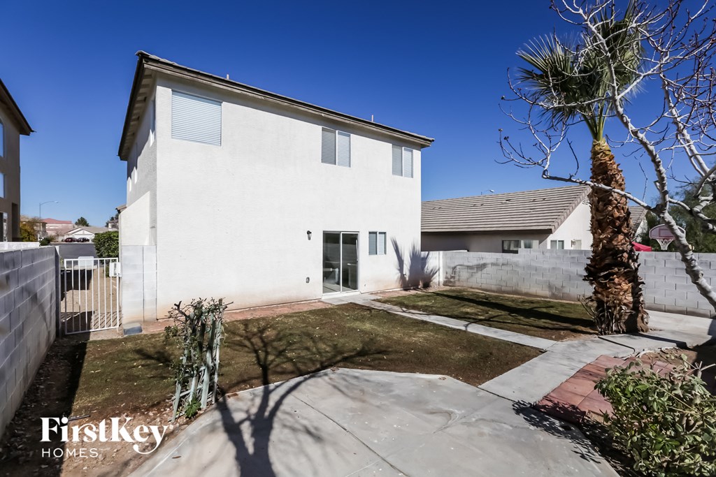 A modern house with a white exterior and a palm tree in the front yard.