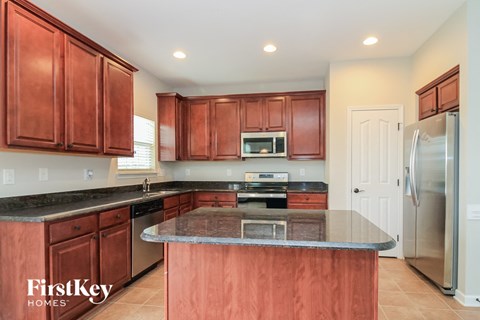A kitchen with brown cabinets and a granite countertop.