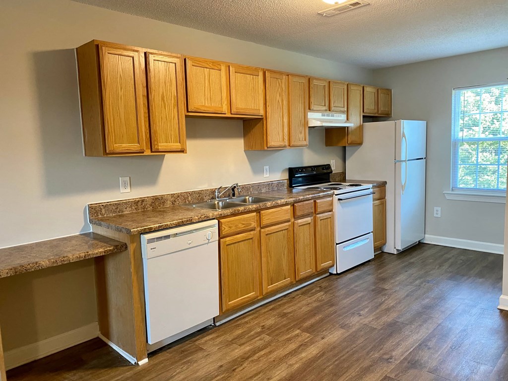A kitchen with wooden cabinets and a white refrigerator.