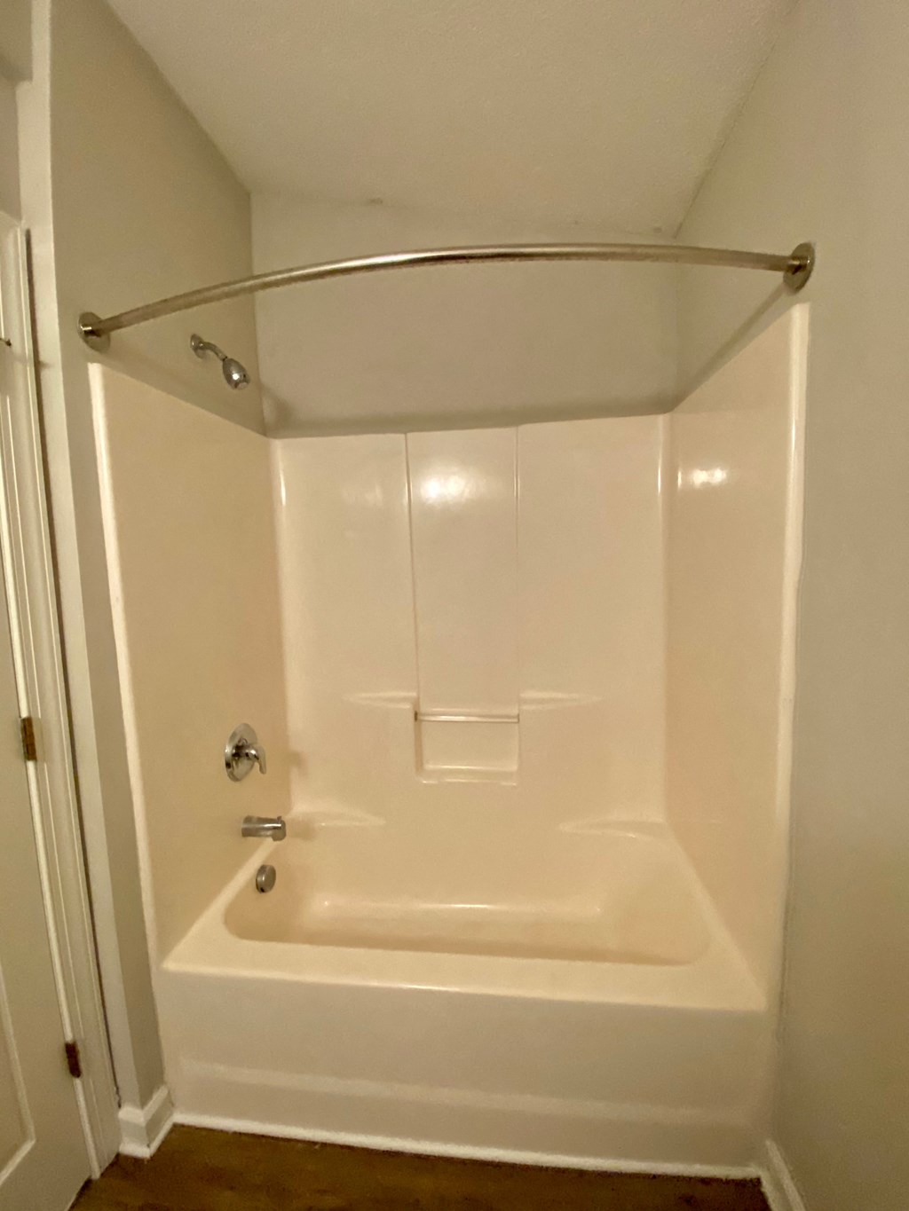 A white bathroom with a tub and a towel rack.