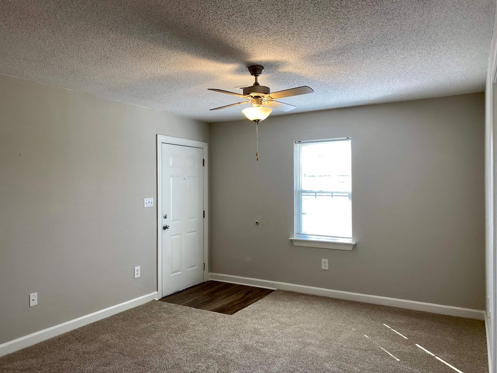 A room with a ceiling fan and a window.