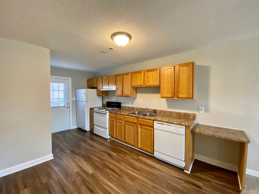 A kitchen with wooden cabinets and a white fridge.