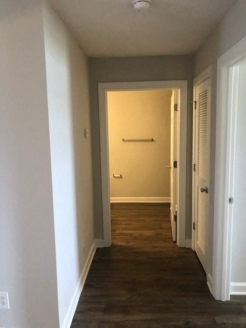 A hallway with a white door and a white wall.