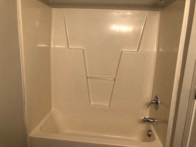 A white bathroom with a door and a handle.