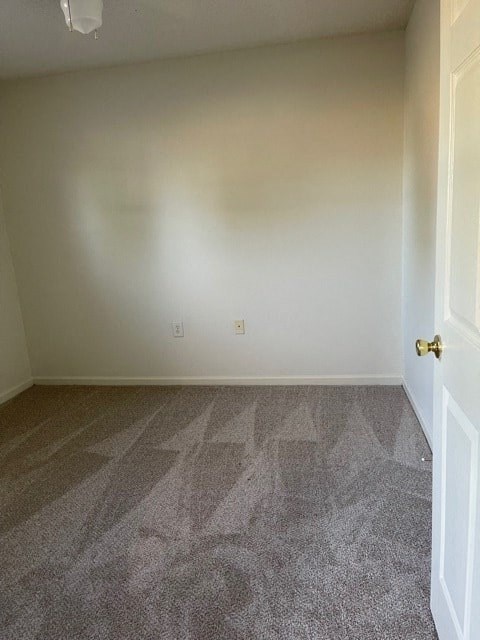 A room with a carpeted floor and a white door.