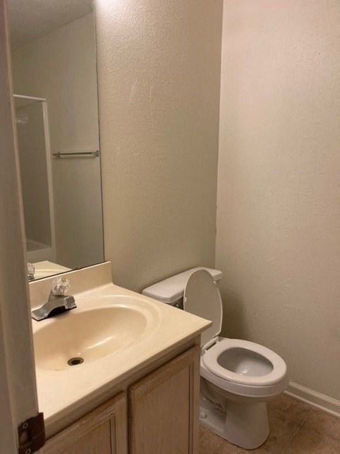 A white toilet sits next to a sink in a bathroom.