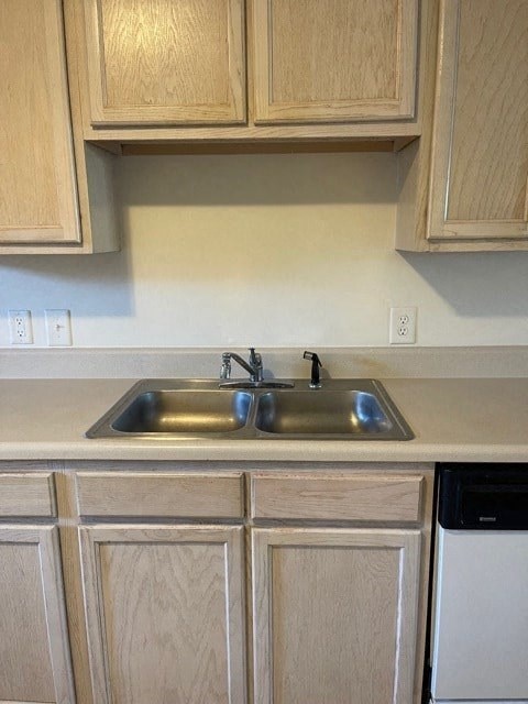 A kitchen with a sink and wooden cabinets.