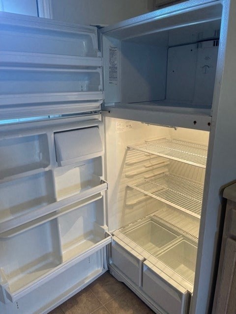 A white refrigerator with the door open and shelves visible.