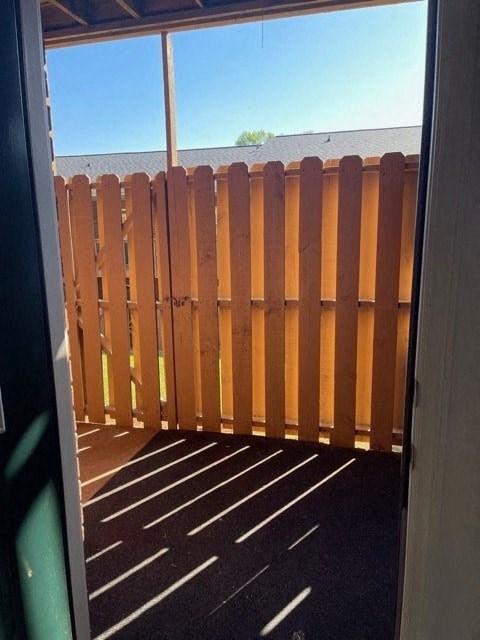 A wooden fence is in front of a house.
