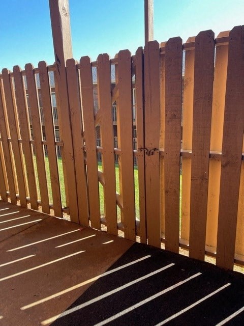 A wooden fence with a black and white striped mat in front of it.