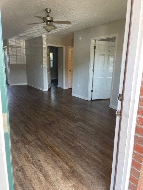 A room with a ceiling fan and wooden flooring.