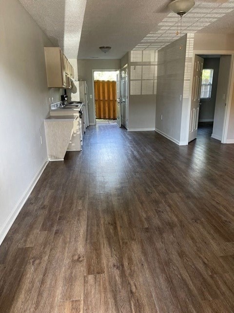 A long hallway with wood floors and white walls.