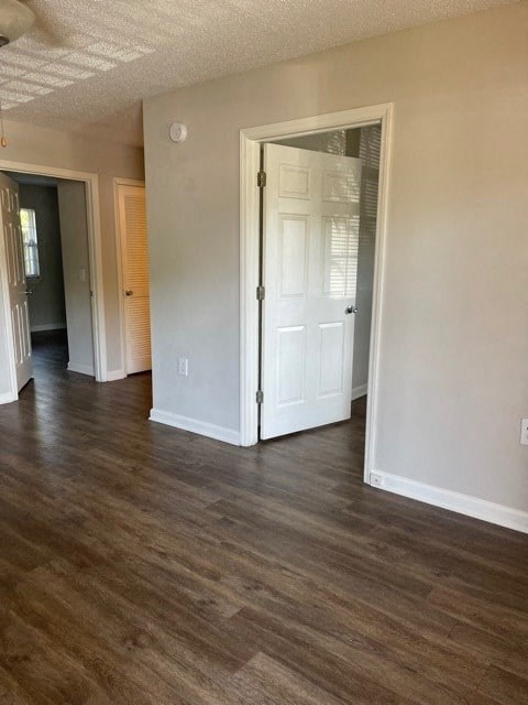 A room with a white door and wooden flooring.