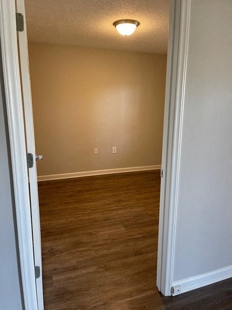 A room with a white door and a light switch on the wall.
