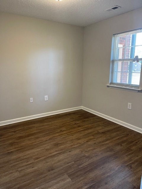 A room with wooden flooring and a window.