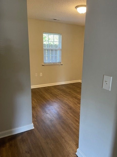 A room with wooden floors and a window with blinds.