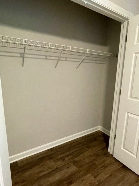 A white door is open to a closet with a wire shelving unit.