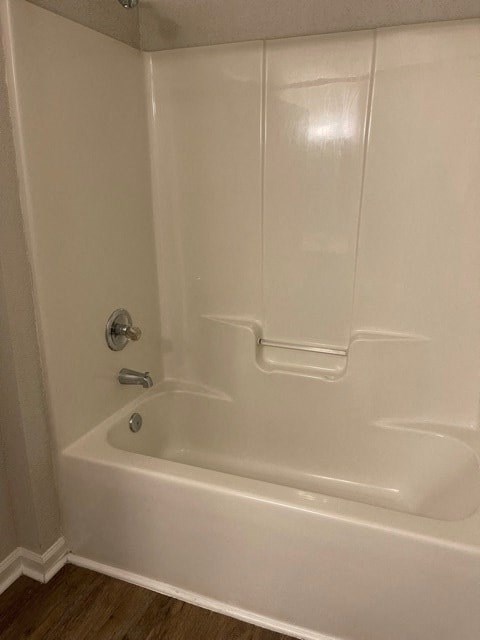 A white bathtub with a silver faucet and a silver handle.