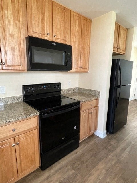 A black stove top oven and microwave in a kitchen.