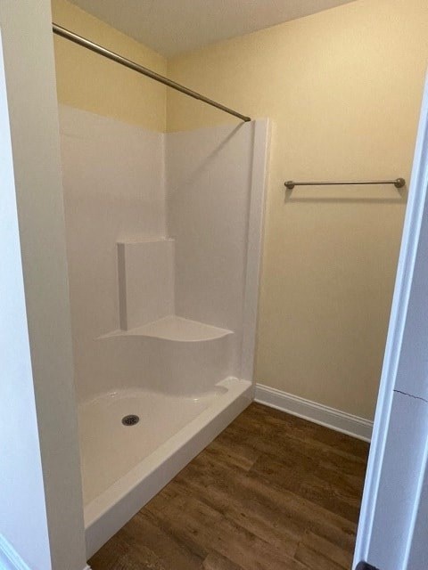 A white bathtub with a shower head and a white door.