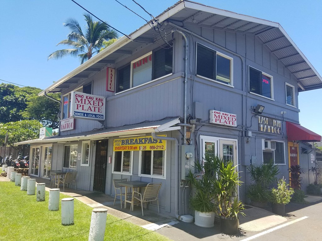 the front of a building with tables and chairs outside of it