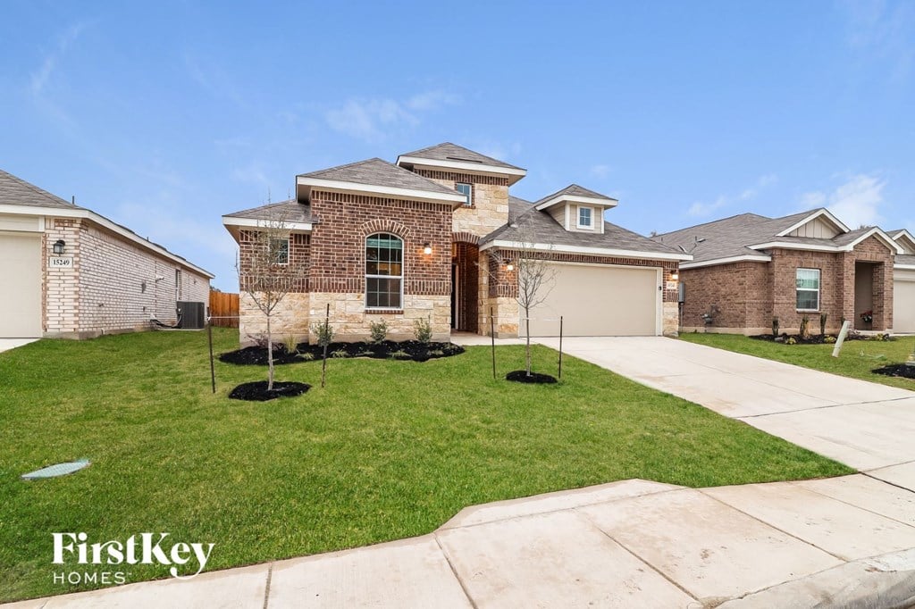 a brick house with a lawn and a driveway