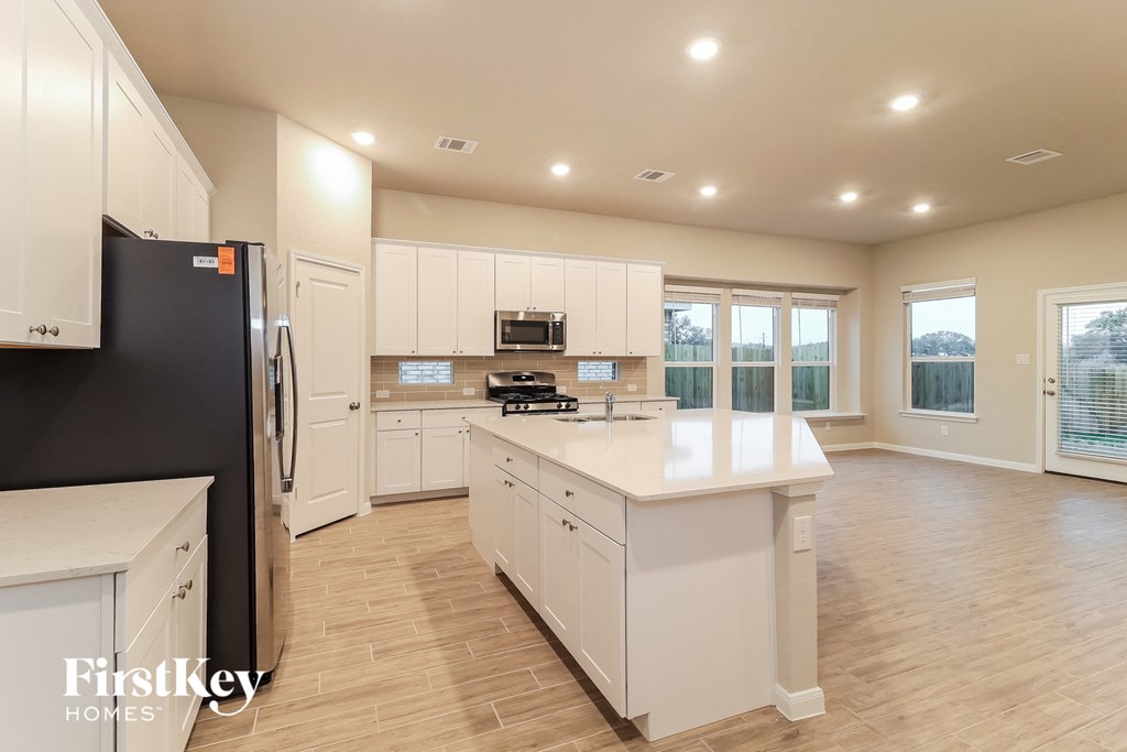 a large kitchen with white cabinets and a white counter top