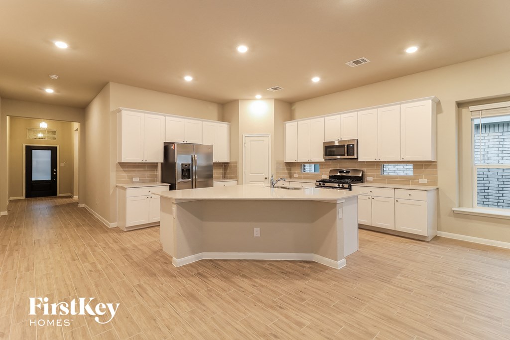 a large kitchen with white cabinets and a large island