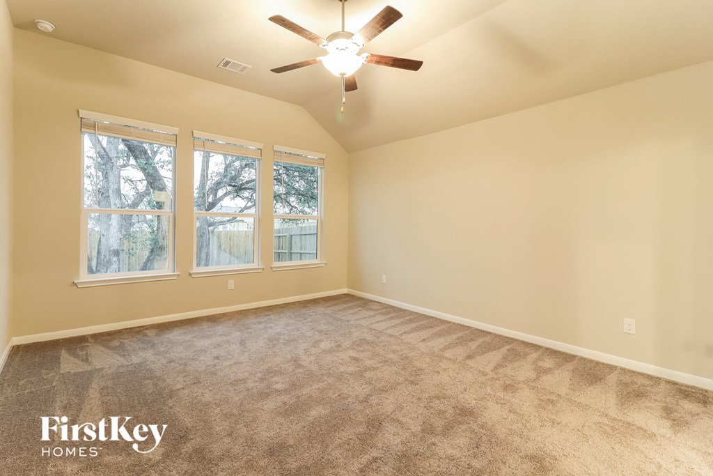 a living room with carpet and a ceiling fan