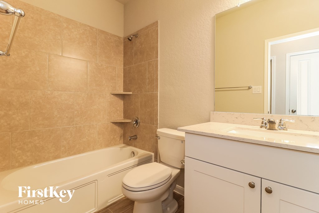 a bathroom with a toilet and a tub and a sink