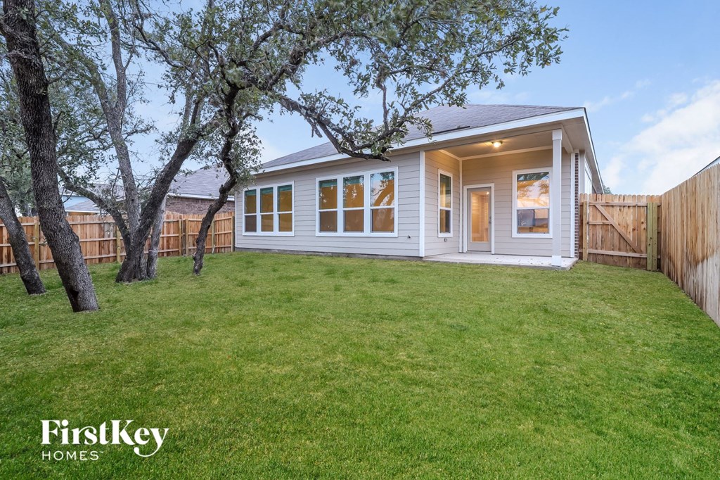 the exterior of a home with a lawn and trees