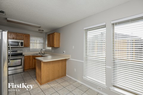 A kitchen with wooden cabinets and a stainless steel refrigerator.