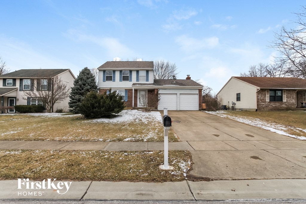 A house with a driveway and a mailbox in front.