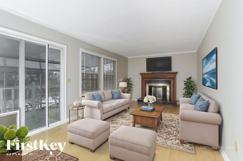 A living room with a fireplace and a flat screen TV.