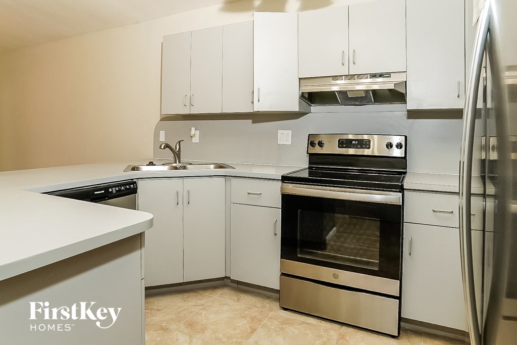 a white kitchen with stainless steel appliances and white cabinets