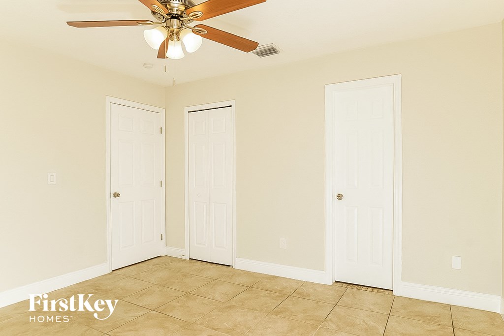 a bedroom with two doors and a ceiling fan