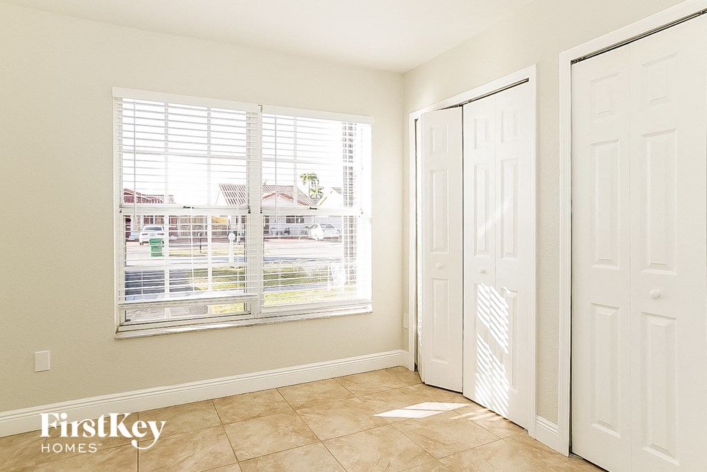 a bedroom with a large window and a door to a closet
