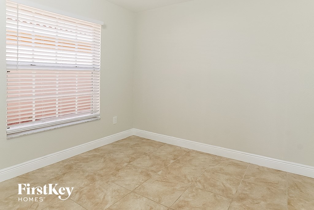 a empty room with a window and a tiled floor