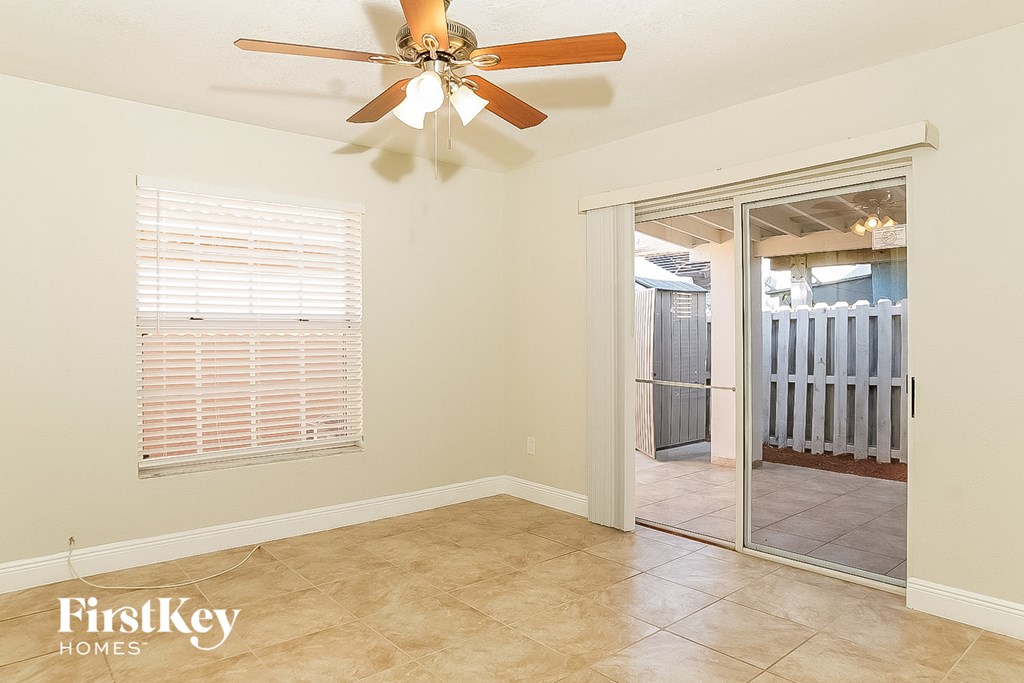 the living room of a home with a ceiling fan and a sliding glass door